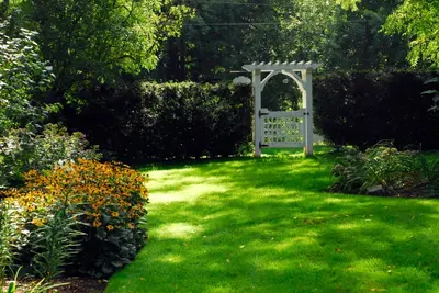 a garden with a gate in the grass at Brockamour Manor Bed and Breakfast in Niagara on the Lake
