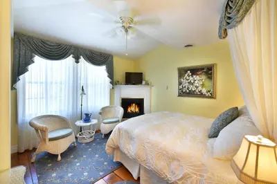 a bedroom with a bed and a fireplace at Brockamour Manor Bed and Breakfast in Niagara on the Lake