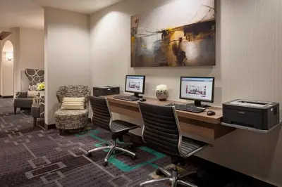 an office with two computers on a desk with chairs at Residence Inn by Marriott Toronto Airport in Toronto