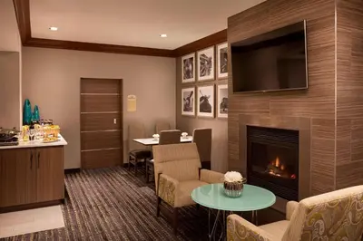 a living room with a fireplace and a table at Residence Inn by Marriott Toronto Airport in Toronto