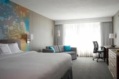 a hotel room with a bed and a couch at Courtyard by Marriott Toronto Downtown in Toronto