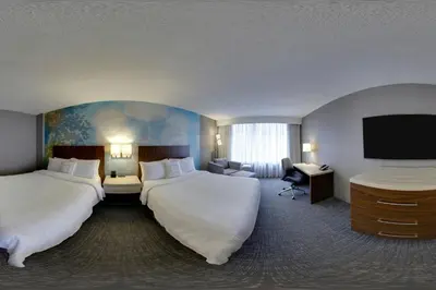 a hotel room with two beds and a flat screen tv at Courtyard by Marriott Toronto Downtown in Toronto