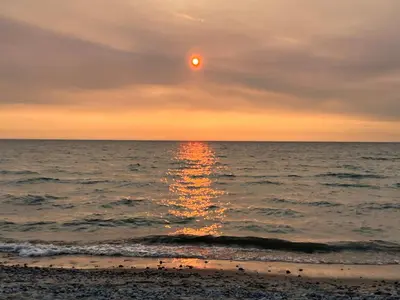 a sunset over the ocean with the sun in the sky at Stunning Modern Beach House with Swimming Pool and Spectacular Sunsets in Tiny