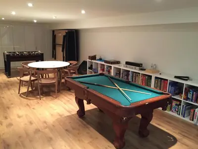 a room with a pool table and a book shelf at Stunning Modern Beach House with Swimming Pool and Spectacular Sunsets in Tiny