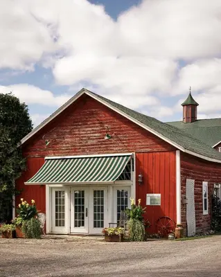 a red barn with a white door at The Eddie Hotel and Farm in Bloomfield
