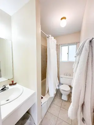 a white bathroom with a sink and a toilet at Oasis by the Bay Vacation Suites in Wasaga Beach