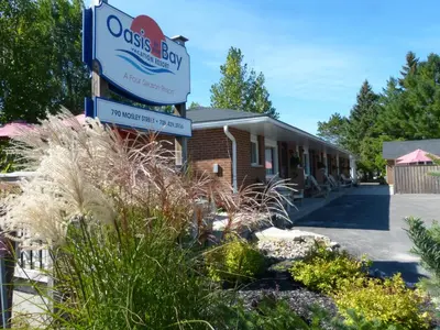 a building with a sign for aossys bay at Oasis by the Bay Vacation Suites in Wasaga Beach
