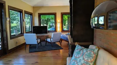 a living room with a couch and a table and chairs at The Front Porch Room of a 140-Year-Old Victorian House in Orangeville