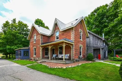a brick house with a gambrel roof at A charming, rustic 150 year old Carriage House in Orangeville