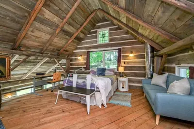 a bedroom with a bed and a couch in a room at A charming, rustic 150 year old Carriage House in Orangeville