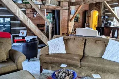 a living room with a couch and two chairs at A charming, rustic 150 year old Carriage House in Orangeville