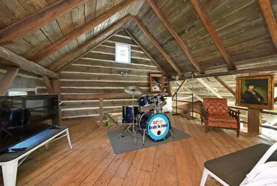 a living room with a drum set in a cabin at A charming, rustic 150 year old Carriage House in Orangeville