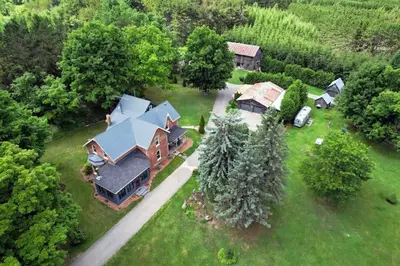 an aerial view of a large house in the woods at A charming, rustic 150 year old Carriage House in Orangeville