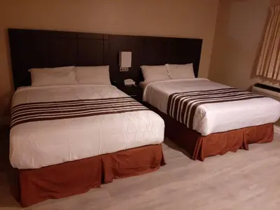 two beds sitting next to each other in a hotel room at Silver Maple Motel in Haliburton