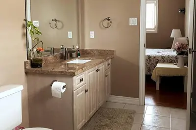 a bathroom with a sink and a toilet and a bed at Aurora Executive Upscale Residence Three Bedrooms Three and Half Bathrooms in Aurora