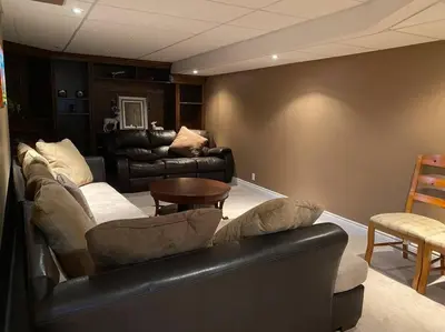 a living room with a leather couch and a table at Aurora Executive Upscale Residence Three Bedrooms Three and Half Bathrooms in Aurora