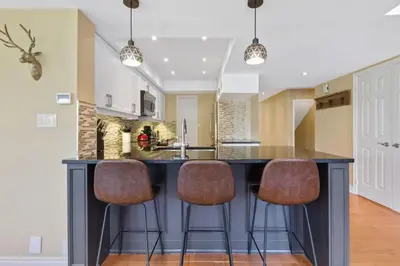 a kitchen with a large island with two bar stools at Luxurious Sierra Lane Escape in Blue Mountains