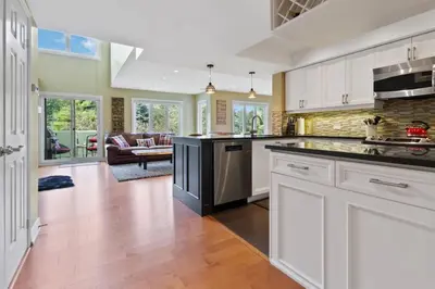 an open kitchen with white cabinets and a living room at Luxurious Sierra Lane Escape in Blue Mountains