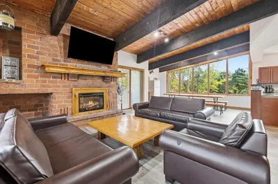 a living room with leather furniture and a fireplace at 12 Beds Sleep 16 Chalet with HotTub, 2min to Blue in Blue Mountains