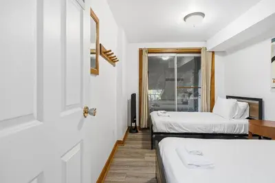 a room with two beds and a window at 12 Beds Sleep 16 Chalet with HotTub, 2min to Blue in Blue Mountains