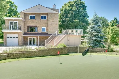 a man playing golf in front of a house at Paradise Manor w Hot tub Sauna & Putting Green in Blue Mountains