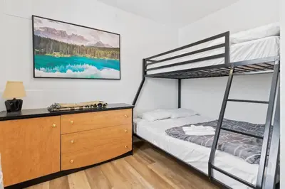a bedroom with a bunk bed and a dresser at Paradise Manor w Hot tub Sauna & Putting Green in Blue Mountains
