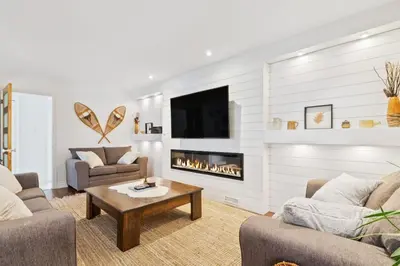 a living room with two couches and a fireplace at Paradise Manor w Hot tub Sauna & Putting Green in Blue Mountains