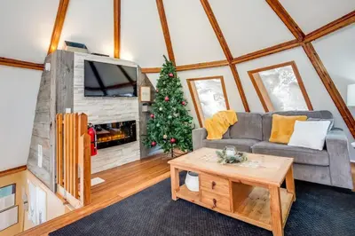 a living room with a couch and a christmas tree at The Beehive w Hot Tub Sauna & Fireplace in Blue Mountains