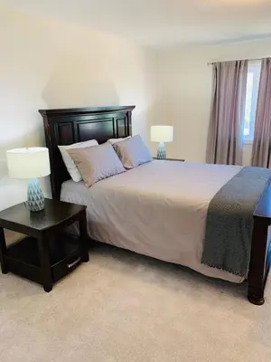 a bedroom with a large bed with two lamps at Close Property in Bowmanville