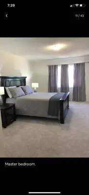 a bedroom with a large bed and a window at Close Property in Bowmanville