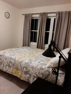 a bedroom with a bed and a clock on the wall at Close Property in Bowmanville