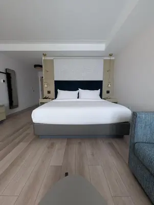a bedroom with a large white bed and a couch at Bloom Mississauga, Tapestry Collection By Hilton in Mississauga
