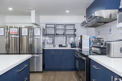 a kitchen with blue cabinets and stainless steel appliances at Samesun Toronto in Toronto