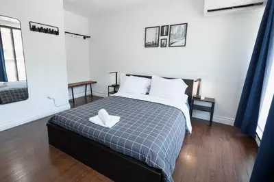 a bedroom with a bed with a blue and white blanket at Samesun Toronto in Toronto