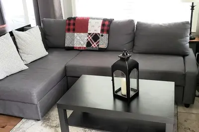 a living room with a gray couch with a table at Hillside BLUE MTN Family Loft @ North Creek Resort in Blue Mountains