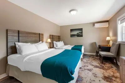 a hotel room with two beds and a chair at Christie's Mill Inn & Spa - BW Premier Collection in Port Severn