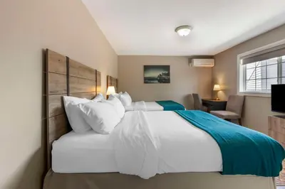 a bedroom with a large white bed and a television at Christie's Mill Inn & Spa - BW Premier Collection in Port Severn