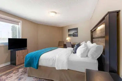 a bedroom with a bed and a flat screen tv at Christie's Mill Inn & Spa - BW Premier Collection in Port Severn