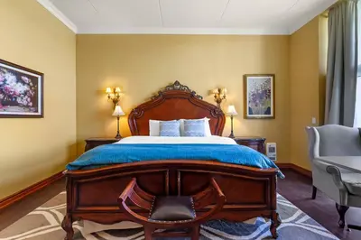 a bedroom with a large wooden bed and a chair at Christie's Mill Inn & Spa - BW Premier Collection in Port Severn