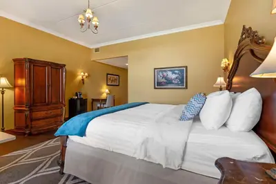 a bedroom with a large white bed with a blue blanket at Christie's Mill Inn & Spa - BW Premier Collection in Port Severn