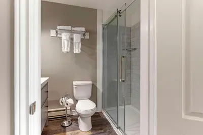 a bathroom with a toilet and a glass shower at Christie's Mill Inn & Spa - BW Premier Collection in Port Severn