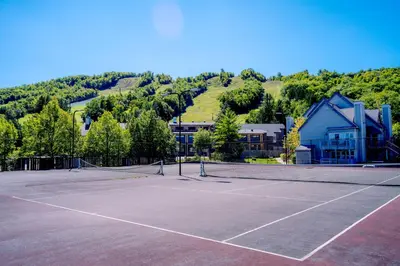 a tennis court in front of a building at Updated Blue Mountain Studio @ North Creek Resort in Blue Mountains