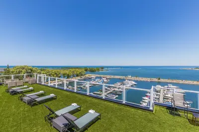 a deck with chaise lounge chairs and a marina at Living Water Resort & Spa in Collingwood