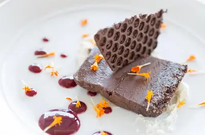 a piece of chocolate cake on a plate with cherries at Living Water Resort & Spa in Collingwood