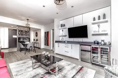 a living room with a kitchen with a tv on the wall at Hyatt Place Toronto-Brampton in Brampton