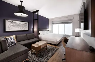 a living room with a couch and a bed at Hyatt Place Toronto-Brampton in Brampton
