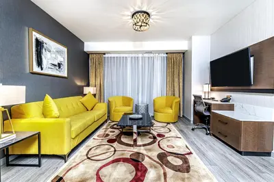 a living room with a yellow couch and a desk at Hyatt Place Toronto-Brampton in Brampton