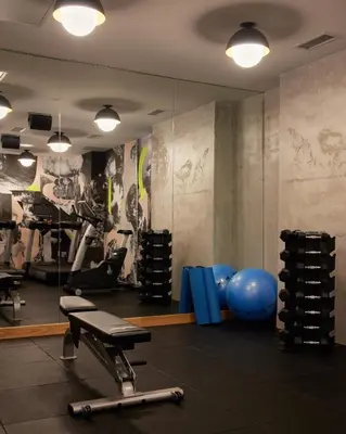 a gym with exercise equipment and a mirror at Ace Hotel Toronto in Toronto