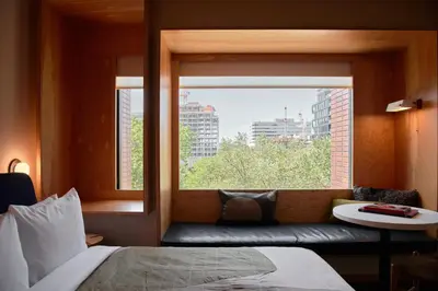 a bedroom with a window and a bed and a couch at Ace Hotel Toronto in Toronto