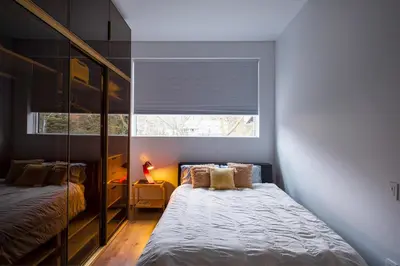 a small bedroom with a bed and a window at Entire Queen Loft in Toronto